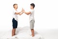 Two smiling brothers clapping hands while standing on bed Royalty Free Stock Photo