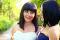 Two smiling brunette women reading a book in a summer park Royalty Free Stock Photo