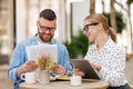 Two smiling business colleagues young man and woman working together on project at outdoor cafe Royalty Free Stock Photo