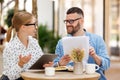 Two smiling business colleagues young man and woman working together on project at outdoor cafe Royalty Free Stock Photo