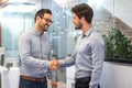 Two smiling business men shaking hands together after successful meeting. Royalty Free Stock Photo