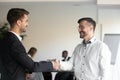 Two smiling business partners shaking hands with each other. Royalty Free Stock Photo
