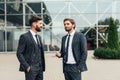 Two smiling businessman colleagues in a blue suit talking and walking business people discussing strategy Royalty Free Stock Photo