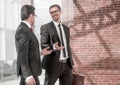 Two smiling businessman walking in the office hall Royalty Free Stock Photo