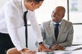 Two smiling businessmen discussing paperwork together in an offi Royalty Free Stock Photo