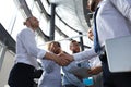 Two smiling businessmen are shaking hands while being in office together with their colleagues Royalty Free Stock Photo