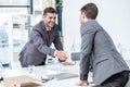 Two smiling businessmen shaking hands at meeting in office Royalty Free Stock Photo