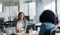 Two smiling businesswoman talking together around an office table Royalty Free Stock Photo
