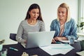 Two smiling businesswomen working with a laptop in an office Royalty Free Stock Photo