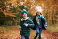 Two Smiling Children Having Fun Running Along Path Through Autumn Woodland Together Royalty Free Stock Photo