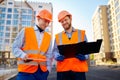 Two smiling construction workers discussing floor plan Royalty Free Stock Photo