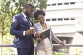 Two smiling coworkers discussing new project while standing outdoors