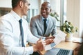 Two smiling diverse businessmen discussing graphs together in an Royalty Free Stock Photo