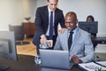 Two smiling diverse businessmen working together on a laptop Royalty Free Stock Photo