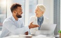 Two smiling diverse colleagues working together on a laptop in an office. Cheerful young mixed race businessman meeting Royalty Free Stock Photo