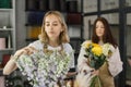 Two smiling female florists working behind counter in modern loft interior of floral shop. Royalty Free Stock Photo