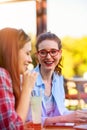 Two smiling female friends talking, drinking coffee outdoors in the city Royalty Free Stock Photo