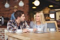 Two smiling friends talking and drinking coffee Royalty Free Stock Photo