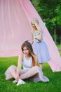 Two smiling funny Caucasian girls sisters wearing pink tutu tulle skirts in park forest meadow at sunset. Friends having fun Royalty Free Stock Photo