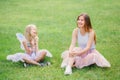 Two smiling funny Caucasian girls sisters wearing pink tutu tulle skirts in park forest meadow at sunset. Friends having fun Royalty Free Stock Photo