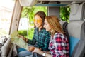 Smiling girl friends with map traveling by tour in bus Royalty Free Stock Photo