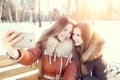 Two smiling girls make selfie in winter park Royalty Free Stock Photo