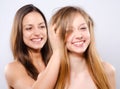 Two smiling girls playing with their beautiful long hairs Royalty Free Stock Photo