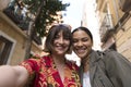 Two smiling girls taking a photo together with mobile phone outdoors Royalty Free Stock Photo