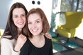 Two smiling happy young women living room in a house