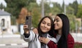 Two smiling lesbian couple latin women are taking a selfie together outdoors Royalty Free Stock Photo