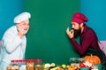 Two smiling male chefs, cooks or bakers with menu blank board. Perfect hand sign.