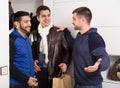 Two smiling men visiting friend at home Royalty Free Stock Photo