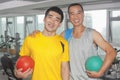 Two smiling men holding balls in the gym Royalty Free Stock Photo