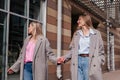 Two smiling mid age women walking on city street holding hands. Female friends outdoors Royalty Free Stock Photo