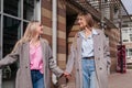 Two smiling mid age women walking on city street holding hands. Female friends outdoors Royalty Free Stock Photo