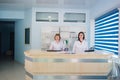 Two smiling nurses working at hospital reception desk Royalty Free Stock Photo