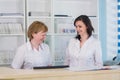 Two smiling nurses working at hospital reception desk Royalty Free Stock Photo