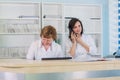 Two smiling nurses working at hospital reception desk Royalty Free Stock Photo