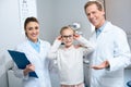 two smiling ophthalmologists and little child