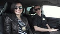 Two smiling police officers sitting in car