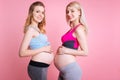 Two smiling pregnancies holding hands on bellies Royalty Free Stock Photo