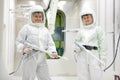 Two smiling professional factory painters workers with spray guns Royalty Free Stock Photo