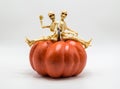 Two skeletons sitting on top of a Halloween pumpkin  on white Royalty Free Stock Photo