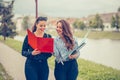 Two smiling students learning reading a notebook and commenting in the street Royalty Free Stock Photo