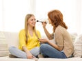 Two smiling teenage girls applying make up at home Royalty Free Stock Photo