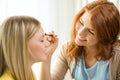 Two smiling teenage girls applying make up at home Royalty Free Stock Photo