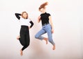 Two teenage girls smiling and jumping friends Royalty Free Stock Photo