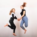 Two teenage girls smiling and jumping friends Royalty Free Stock Photo