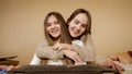 Two smiling teenage girls have video call on laptop at home. Remote work, communication and education Royalty Free Stock Photo