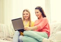 Two smiling teenage girls with laptop at home Royalty Free Stock Photo